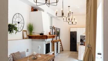 A modern kitchen with a central island, pendant lighting, and a dining area with a wooden table and bench.