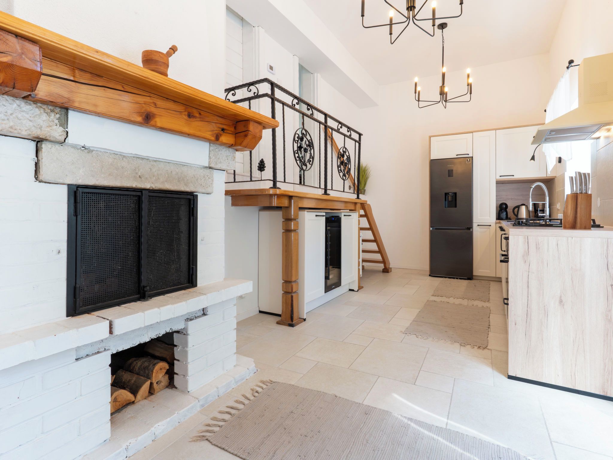 A modern kitchen with a built-in stove, a refrigerator, and a dining area with a wooden table.