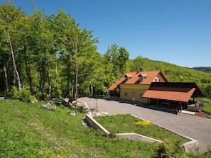 A two-story house with a red roof, surrounded by lush greenery and trees. - Vacation home Vršak by Interhome (Senj)