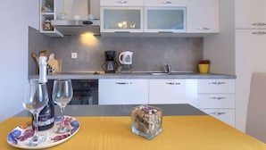 A modern kitchen with white cabinets, a coffee maker, and a small sink. - Apartment Lili by Interhome (Poreč)