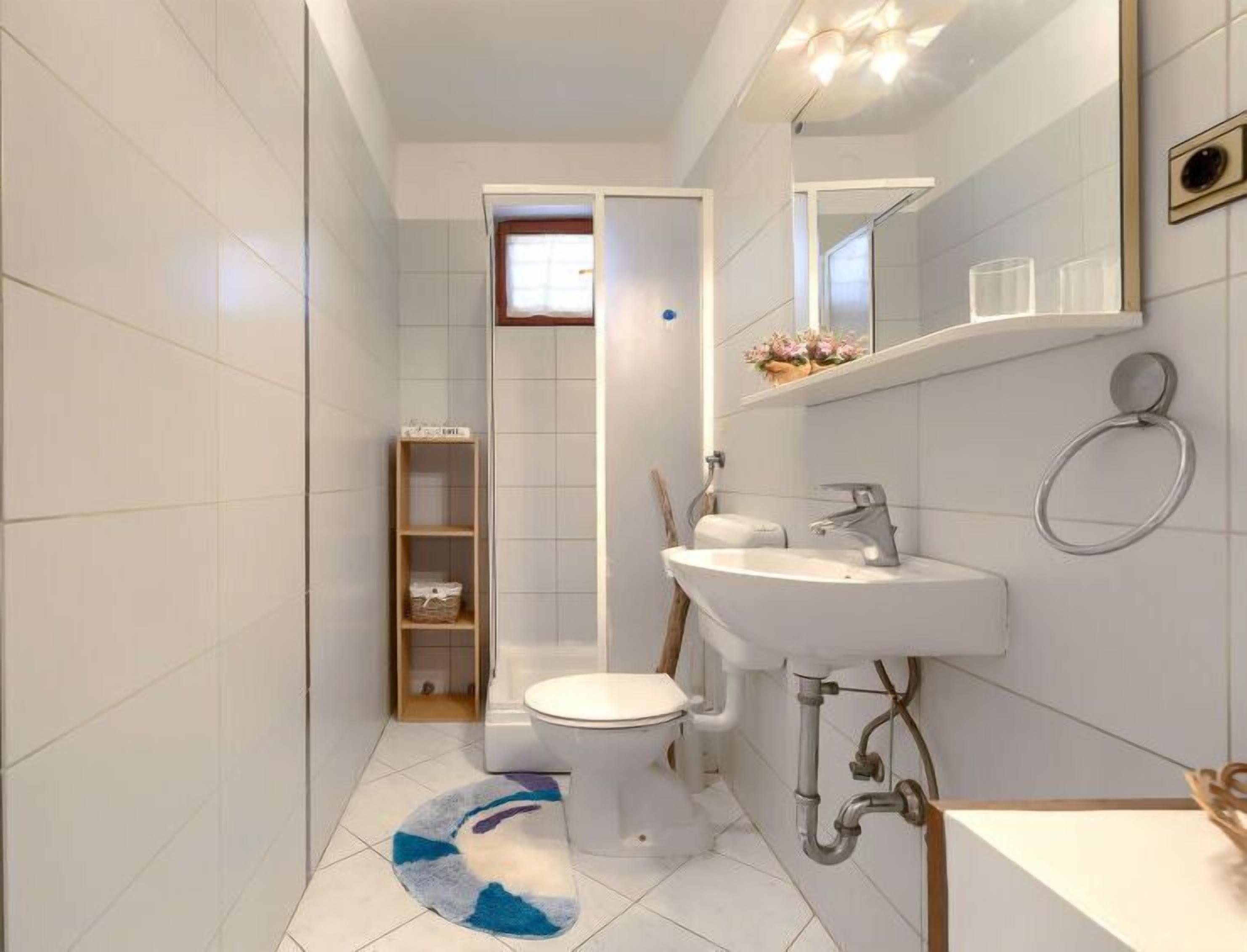A modern bathroom with a toilet, sink, and shower area.
