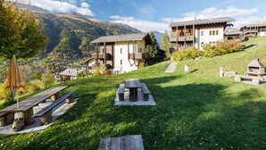 A mountain resort with wooden buildings, picnic tables, and a clear view of the surrounding mountains.