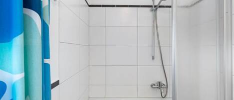 A bathroom with a shower, a bathtub, and a curtain.