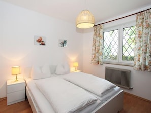 Cozy retreat with a bed, bedside tables, and artwork, set against a bright and airy backdrop.