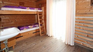 A wooden cabin room with bunk beds, a sink, and a window with curtains. - Haslwanter by Interhome (Pians)