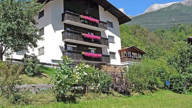 A multi-story hotel with balconies adorned with flowers, set against a mountainous backdrop. - Haslwanter by Interhome (Pians)