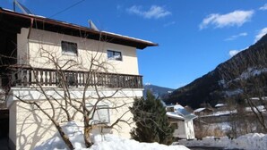 A two-story building with a balcony, surrounded by snow and mountains. - Haslwanter by Interhome (Pians)