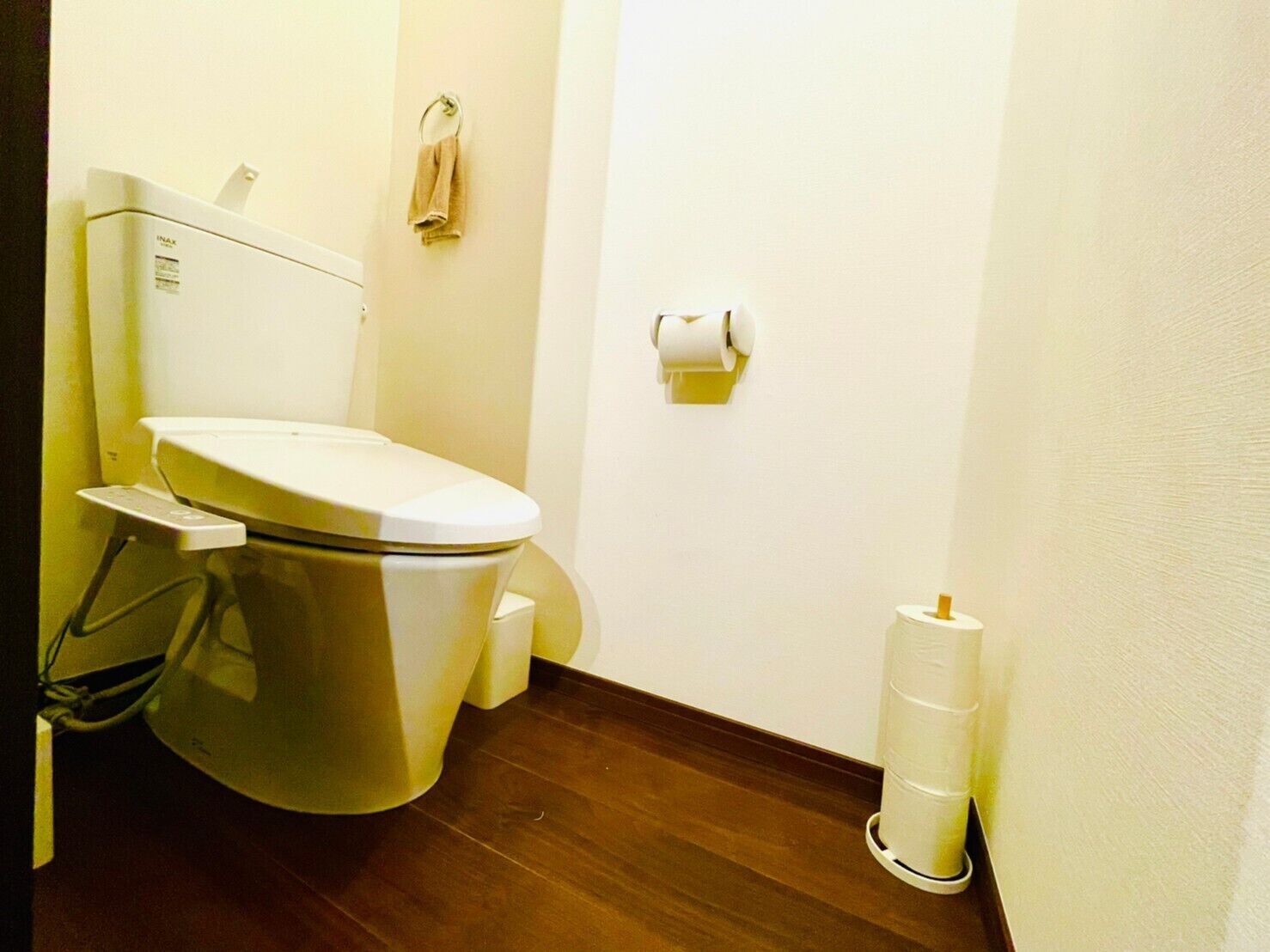 Un baño pequeño y funcional con inodoro, toallero y dispensador de papel higiénico.
