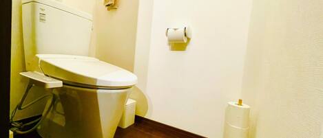 Un baño pequeño y funcional con inodoro, toallero y dispensador de papel higiénico.
