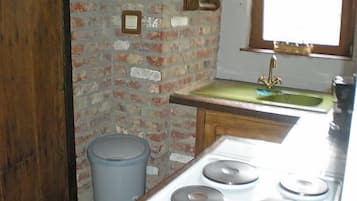 Een koelkast, een microgolfoven, kookgerei, borden en bestek