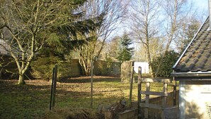 A stone building with a tiled roof, surrounded by a grassy area with trees and a fence. - Ma Campagne by Interhome (Trois-Ponts)