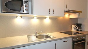 A modern kitchen with a microwave, sink, stove, and cabinets. - Apartment Liebl by Interhome (Seefeld in Tirol)