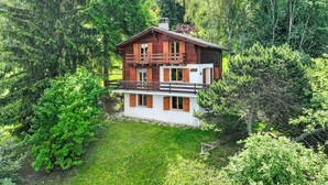 A two-story wooden house surrounded by dense forest. - Les Etoiles by Interhome (Nendaz)