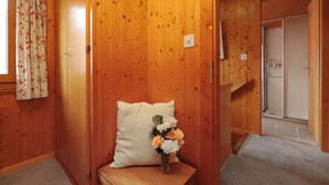 A wooden interior with a bench, a pillow, and a vase of flowers. - Coucordin by Interhome (Nendaz)