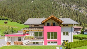 A modern two-story house with a large balcony, a separate garage, and a well-maintained lawn. - Bella Monte by Interhome (Pettneu am Arlberg)