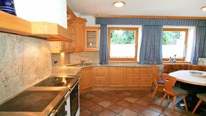 Une cuisine équipée d’une cuisinière, d’un four et de meubles de rangement en bois.