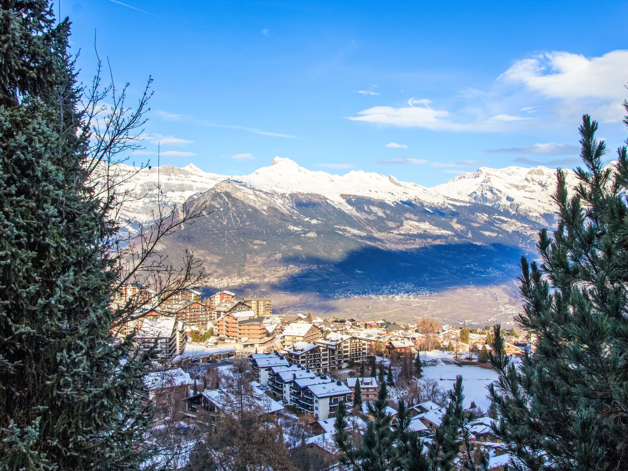 A mountainous town with snow-covered buildings and a clear view of the surrounding peaks.