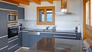 Een moderne keuken met inbouwapparatuur, een groot eiland en een raam met uitzicht.