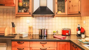 Eine Küche mit Holzausstattung, einem Herd, einer Kaffeemaschine und einer Mikrowelle.
