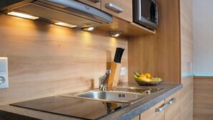 Una cocina moderna con encimera de granito, pileta de acero inoxidable y muebles de madera.