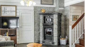Una sala de estar con chimenea, televisor y escalera.