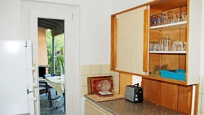 Una cocina con armarios de madera, una encimera y vistas a un patio exterior.