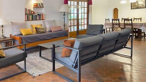 A modern living room with a sofa, armchair, and a dining table with chairs. - Hermine by Interhome (L'Escala)