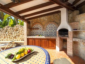 Enjoy casual dining in this outdoor kitchen with oven and pizza oven.