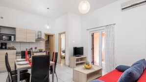 A modern apartment with a dining area, a living room with a sofa, a TV, and a kitchen. - Apartment Tea by Interhome (Krk/Šilo)