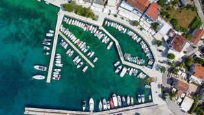 An aerial view of a marina with boats docked in a semi-circular arrangement, surrounded by residential buildings. - Vacation home Vesna by Interhome (Krk/Njivice)