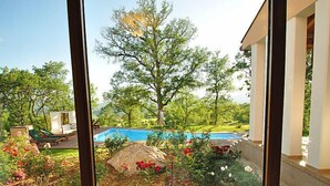 A view from a window overlooking a swimming pool, lush greenery, and outdoor seating. - Vacation home Vesna by Interhome (Buzet)