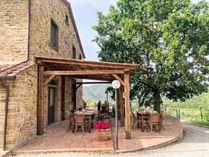 A stone building with a wooden pergola and outdoor seating area. - Vacation home Zen by Interhome (Castiglion Fiorentino)
