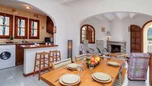 Une cuisine spacieuse avec un coin repas, une cheminée et une vue sur l’extérieur.