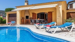 Une piscine avec des chaises longues, un espace barbecue et une vue sur le paysage environnant.