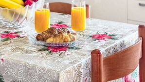 A kitchen with a table set for breakfast, including fruits, juice, and croissants. - Apartment  Ana by Interhome (Porec/Jehnici)