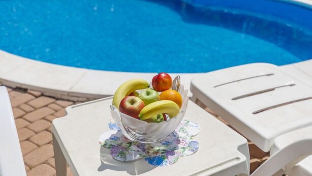 A clear view of a swimming pool with a bowl of fruit on a table. - Apartment  Ana by Interhome (Porec/Jehnici)