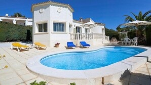 Ein Poolbereich mit Pool, Liegestühlen und einem Gebäude mit Balkon.