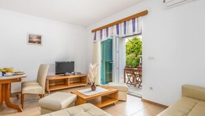 A modern living room with a TV, sofa, and dining area. - Tomislav 3 by Interhome (Rab/Kampor)