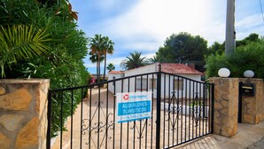 Une entrée fermée par un portail, avec une enseigne indiquant « Interhome Group » et « Alquilos Turísticos ».