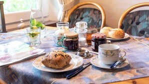 Un tavolo apparecchiato con un muffin, un servizio da tè e condimenti, che suggerisce un'ambientazione per colazione o uno spuntino.