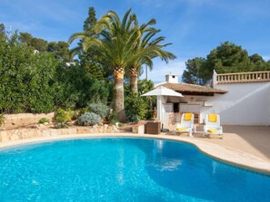 A swimming pool with lounge chairs and a small patio area. - La Concha by Interhome (Jávea)