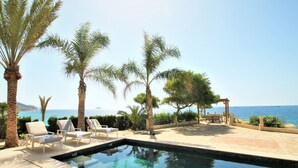 A pool area with lounge chairs and a pergola overlooking the sea. - Casa Taty by Interhome (El Campello/Villajoyosa)