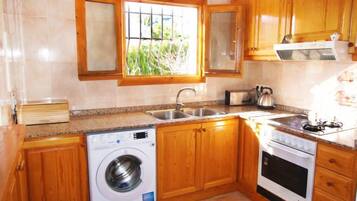 Een koelkast, een magnetron, een oven, kookgerei, borden en bestek