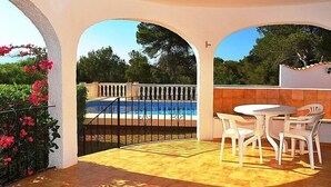 A covered patio with a pool, white chairs, and a view of the pool. - Balcon al Mar by Interhome (Jávea)
