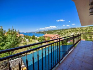 Ein Balkon mit Blick auf ein Schwimmbecken und eine Berglandschaft.