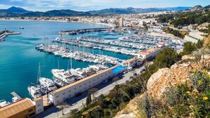 A marina with numerous boats docked, a coastal town in the background, and a prominent building with a blue roof in the foreground. - Vacation home Lucie by Interhome (Jávea)