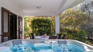 A hot tub area with a table and chairs, surrounded by trees and a pergola. - Apartment Anica by Interhome (Zadar)