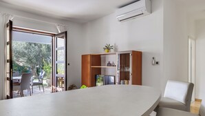 A modern living room with a curved white table, a built-in wooden cabinet, and a white armchair. - Apartment Anica by Interhome (Zadar)