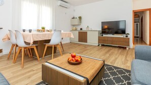A modern living room with a dining area, a TV, and a kitchen area. - Vacation home Antem by Interhome (Lloret de Mar)
