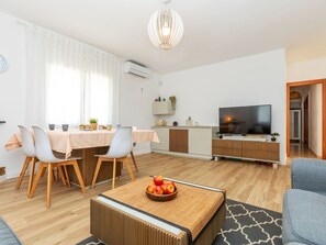 A modern living room with a dining area, a TV, and a kitchen area. - Vacation home Antem by Interhome (Lloret de Mar)